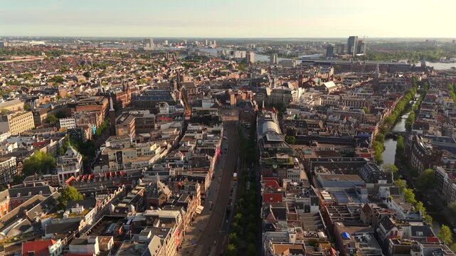 High altitude drone pushes forward above central Amsterdam city center revealing historic neighborhoods and canals