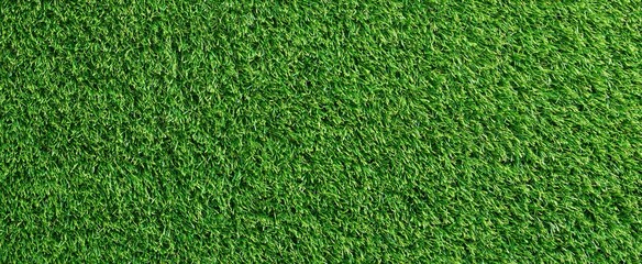 Obraz premium A vibrant green artificial turf field viewed from above, highlighting smooth texture and rich color ideal for outdoor sports.