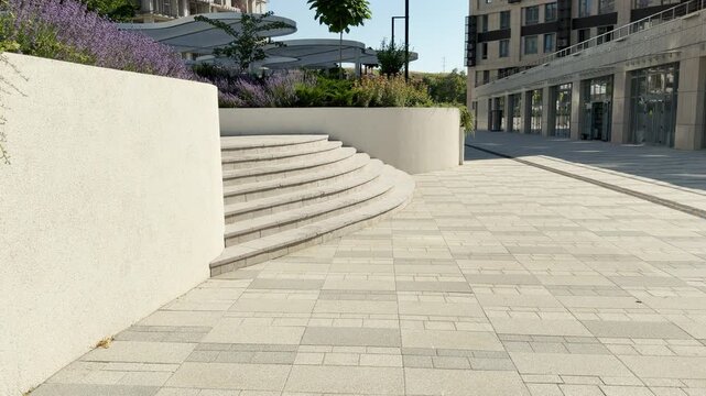 A clean stone plaza sits quietly under the bright sun in Simferopol, Crimea. Curved stairs lead to beautiful purple flowers, creating a peaceful and serene feeling.