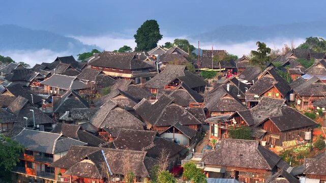 Wengji Village on a Hill in Yunnan, China. The Birthplace of Pu-Erh Tea. Ancient tea tree Forest. Aerial at Sunrise