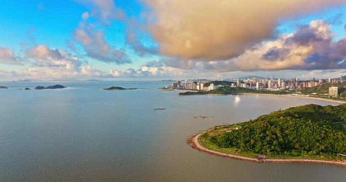 Aerial drone view of modern coastal city skyline and the sea under a dramatic sky, Zhuhai, China