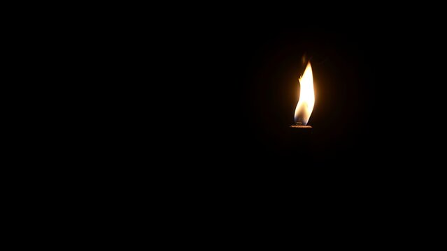 A single burning torch creating a focal point of light in darkness.
