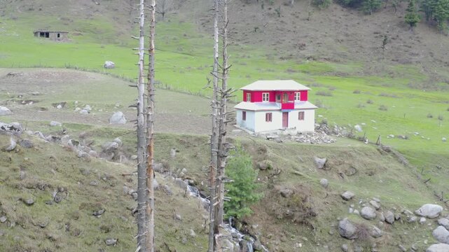 Aerial view of an isolated off-grid home surrounded by nature and mountain stream