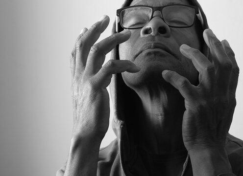 A serene portrait of a man praying with hands together in deep prayer that perfectly captures themes of faith, hope, mindfulness, and inner peace stock image stock photo