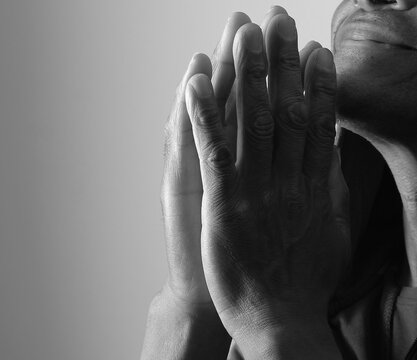 A serene portrait of a man praying with hands together in deep prayer that perfectly captures themes of faith, hope, mindfulness, and inner peace stock image stock photo