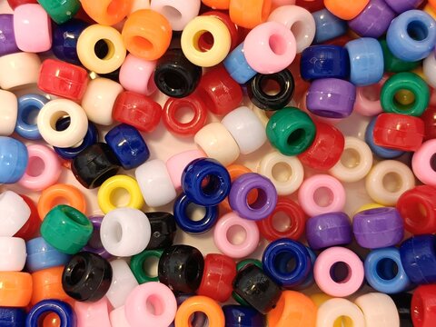 Colorful buttons background, Mixed plastic beads texture for kids sensory play, school art crafts, development activities, and colorful hobby supplies.