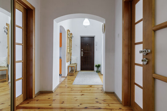 Apartment Corridor Interior with Wooden Doors and Arch