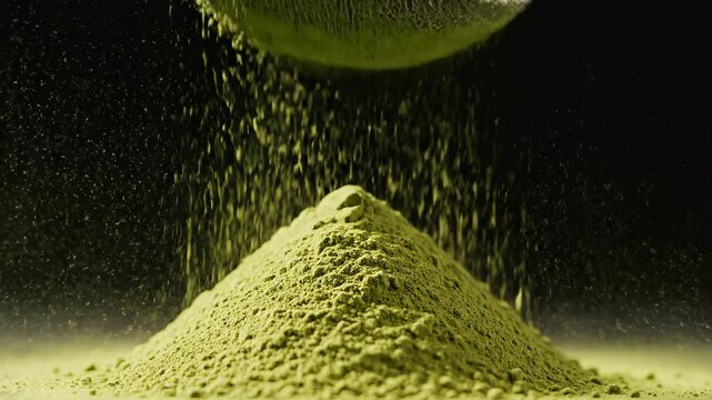 Vibrant Matcha Sifting: Fine Green Tea Powder Falling Through a Sieve onto a Mound Against a Black Background, Ideal for Health and Wellness Content.