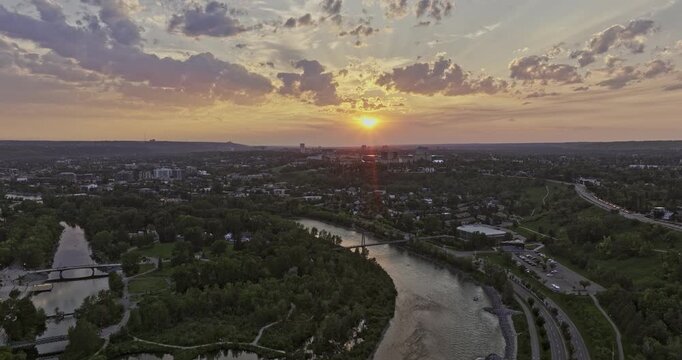 Calgary AB Canada Aerial v48 cinematic reverse flyover across Bow river capturing Prince's Island Park, Eau Claire, Chinatown and Downtown cityscape at sunset - Shot with Mavic 3 Pro Cine - July 2023