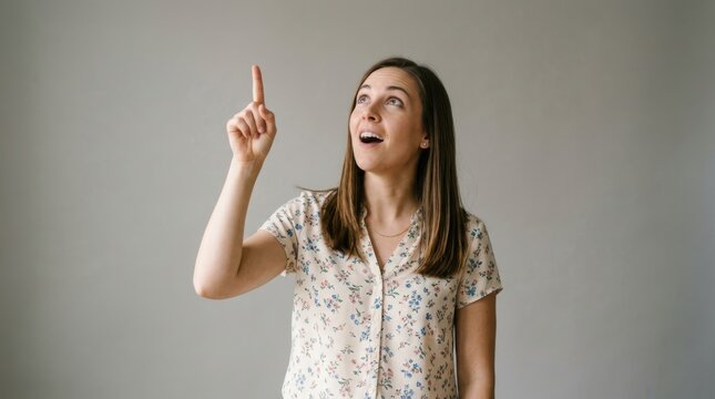 Woman pointing upwards with surprised expression