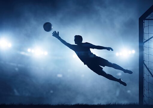 Professional Goalkeeper Leaping to Make a Dramatic Save During a Night Match