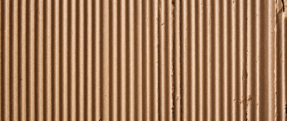 Fototapeta premium Natural Brown Corrugated Cardboard Texture Background with Vertical Ribbed Pattern, High Detail Rough Paper Surface for Sustainable Packaging Design, Minimalist Backdrop with Warm Earthy Tones