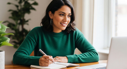 Naklejka premium Woman in green sweater writing in notebook with laptop, symbolizing productivity, education, and remote work for modern lifestyle concepts