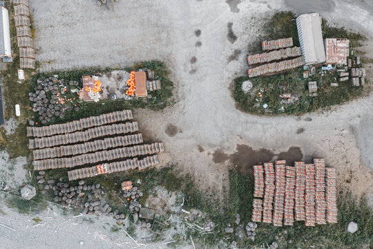 Aerial view of numerous crab pots and fishing traps stacked in an industrial storage yard in Unalaska, Alaska, United States.