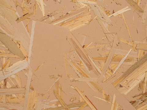 Natural OSB wood chipboard texture background with rustic beige compressed wooden flakes, ideal for modern construction design projects, interior wall paneling, and organic architectural surface