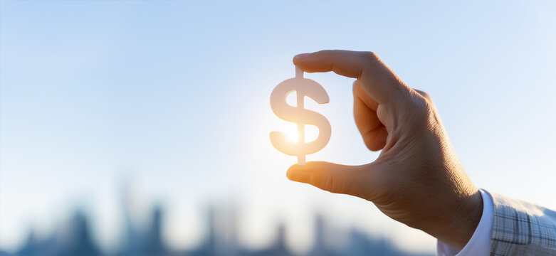 Business Hand Holding Dollar Sign With Sunlight and City Skyline