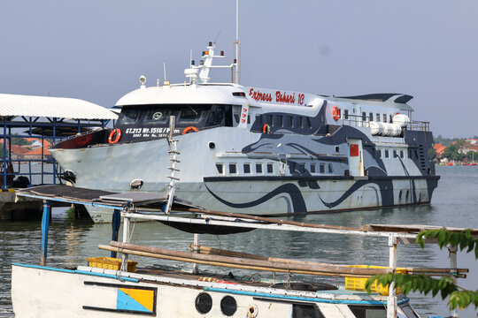 The Express Bahari 1C fast ferry boat docked at the harbor pier, preparing to transport passengers across the sea. Jepara, Indonesia.