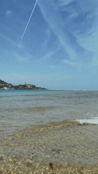 Vista panor&aacute;mica de la playa de Laida en la r&iacute;a de Urdaibai, con la isla de Izaro al fondo, aguas cristalinas, arena fina y un entorno natural verde bajo el cielo azul.