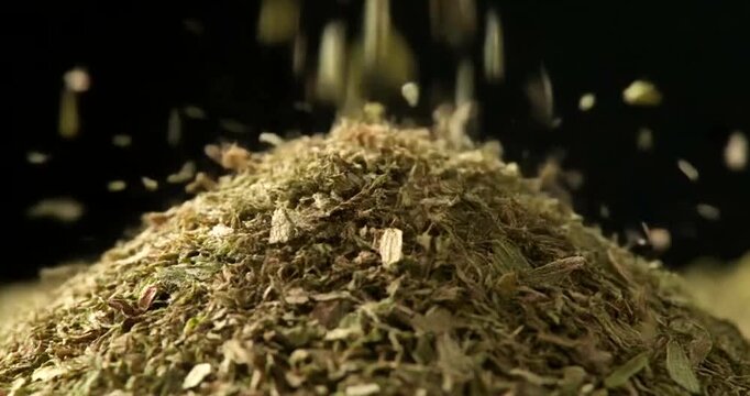 Dried Herbs Pouring Down Creating a Large Pile Slow Motion Close Up.
