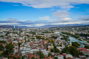 Panoramic Tbilisi cityscape with Kura River, Bridge of Peace, Public Service Hall, and modern architecture, Georgia. © Greggory Zzyzx