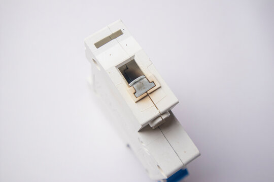 close-up shot focusing on the top terminal section of a white miniature circuit breaker, displaying visible signs of heat discoloration and oxidation on the internal metallic connector