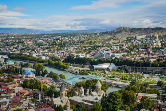 Panoramic view of Tbilisi, Georgia, featuring Mtkvari River, Bridge of Peace, and Rike Park Concert Hall.
