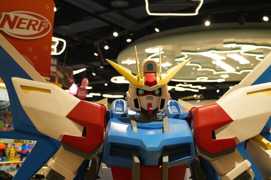 A large Gundam robot statue displayed inside a toy shop.