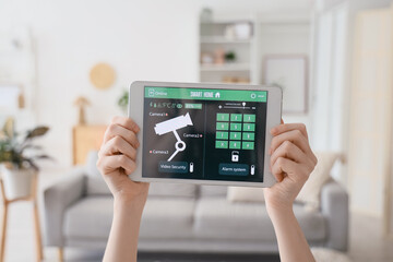 Person holding tablet with smart home security interface © Pixel-Shot