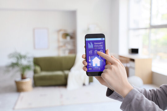 Person controlling smart home system on smartphone