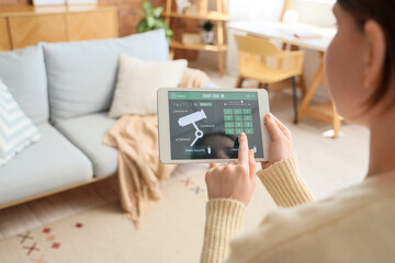 Person controlling smart home security system on tablet © Pixel-Shot