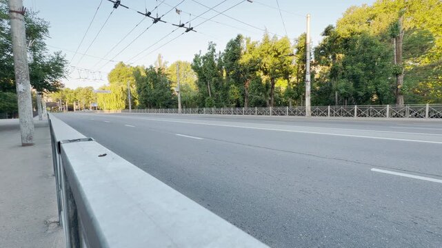A completely empty asphalt road stretches across a bridge in Simferopol, Crimea. The desolate street brings a peaceful yet lonely feeling of deep silence under the bright sun.