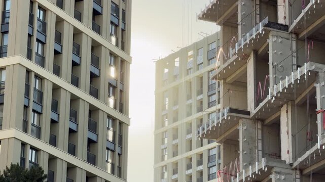 Modern residential towers rise in Simferopol, Crimea, glowing under the warm sun. This striking contrast between finished and developing buildings evokes powerful feeling of growth and urban optimism.