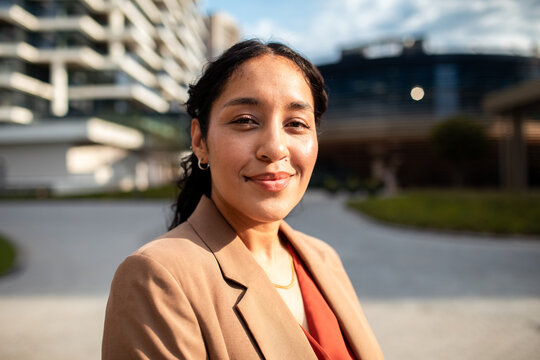 Confident businesswoman smiling outdoors in modern office district