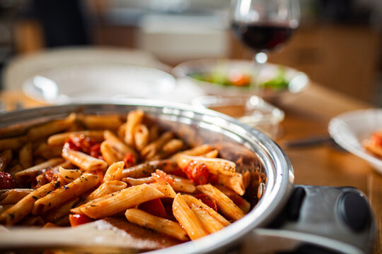 Family dinner penne pasta on kitchen table