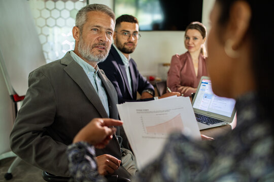Business team reviewing growth charts in office meeting room