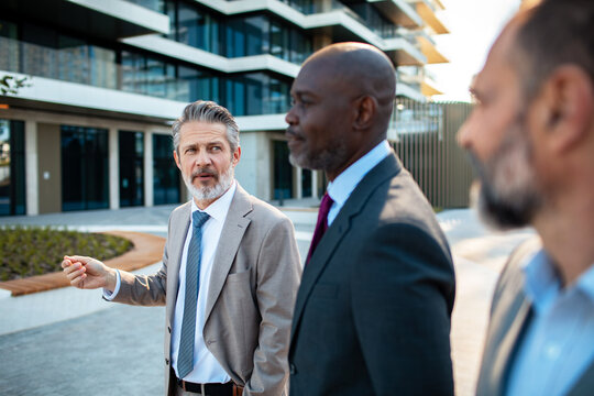 Business executives discussing strategy outside modern office