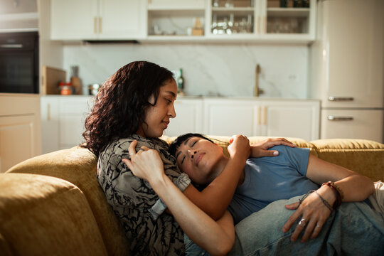 Affectionate couple cuddling on sofa at home
