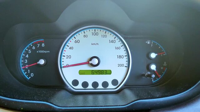 Static view of a clean car dashboard instrument cluster featuring a white speedometer dial and odometer reading, capturing the essential interior details of a vehicle