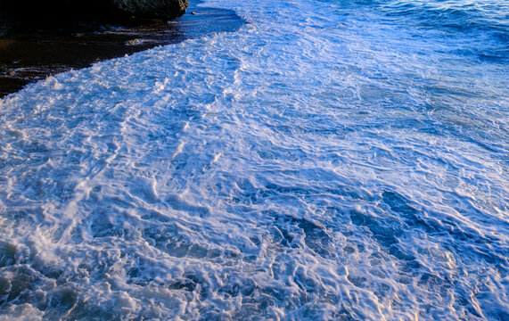 Mesmerizing swirls of bright sea foam creating beautiful natural patterns on the ocean surface