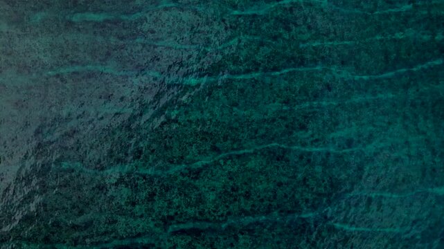 Overhead perspective ocean waves breaking over shallow coral reef. Unique aerial view drone
