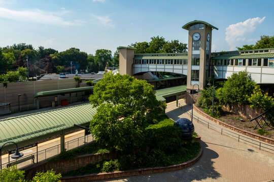 Ramsey, NJ - US - Jul 1, 2026 the Ramsey Route 17 station in New Jersey. A tall clock tower and a modern pedestrian overpass bridge the tracks, set against lush summer greenery.