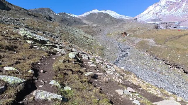 POV 4k video hiking on a mountain trail with scenic view of Gergeti glacier in Georgia.