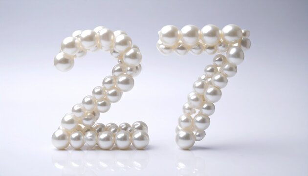The number 27 is creatively formed with pearls on a white surface.