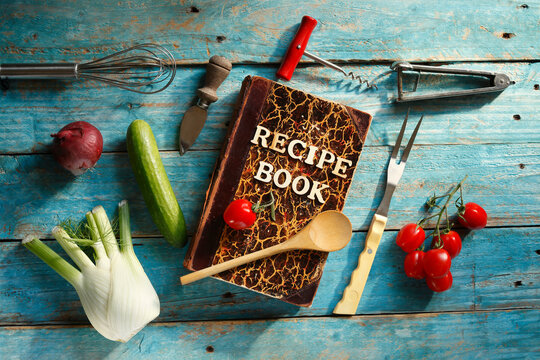 vintage recipe or cook book, various vegetables and vintage kitchen utensils