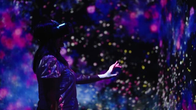 Woman with VR headset inside immersive digital light installation