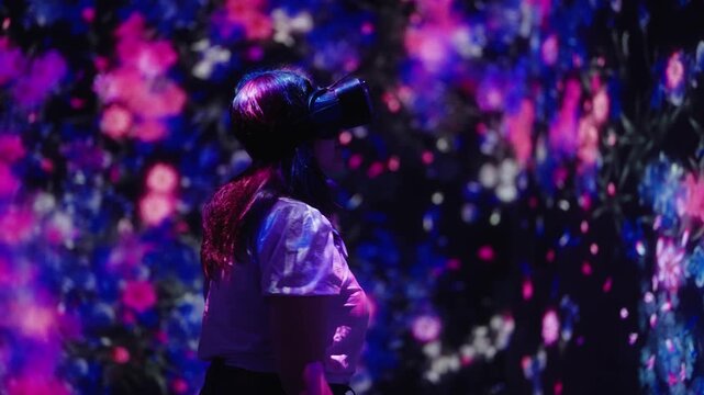 Woman with VR headset inside immersive digital light installation