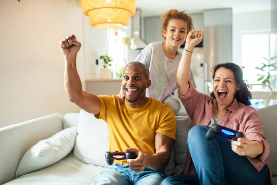 Happy family celebrating while playing video games at home
