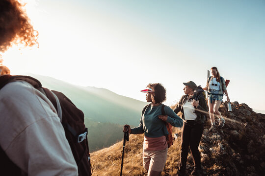 Group of women hiking on mountain ridge at sunrise