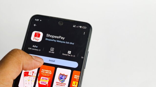 Ipoh,Malaysia - 04 July 2026: A hand hovers near the "Install" button for the ShopeePay app on a smartphone screen, displayed against a clear white background.