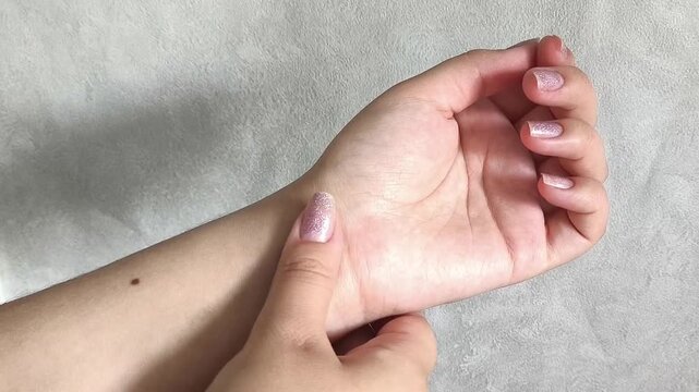 Woman checking pulse on wrist, heart health, cardiovascular wellness and vital signs monitoring concept.